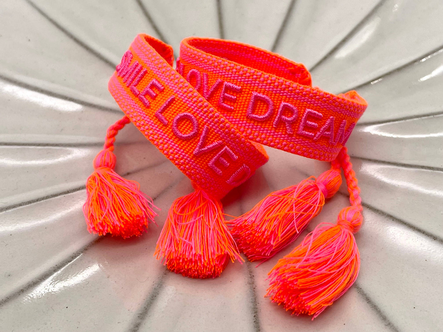 Hier ist die Produktbeschreibung für das "SMILE LOVE DREAM" Statement Armband mit einer passenden Überschrift: SMILE LOVE DREAM – Gewebtes Statement-Armband mit Stil